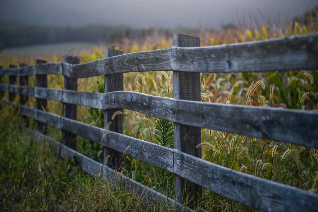 A wooden fence separating two fields
